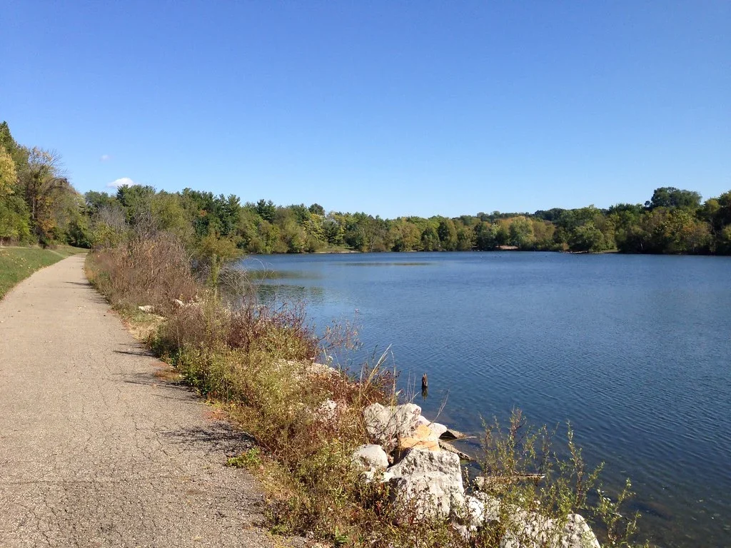 Paved lakeside path and water at Cenci Lake in Lancaster