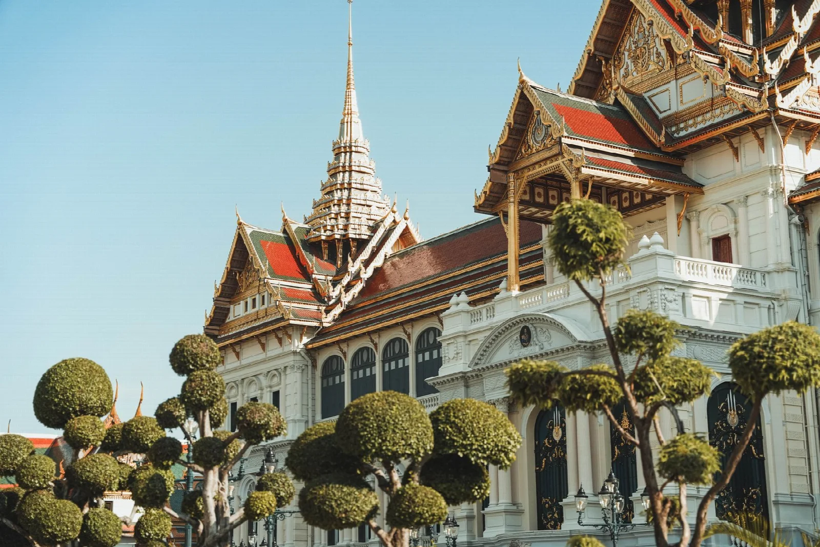 Ornate palace buildings and trees in the Grand Palace courtyard, Bangkok