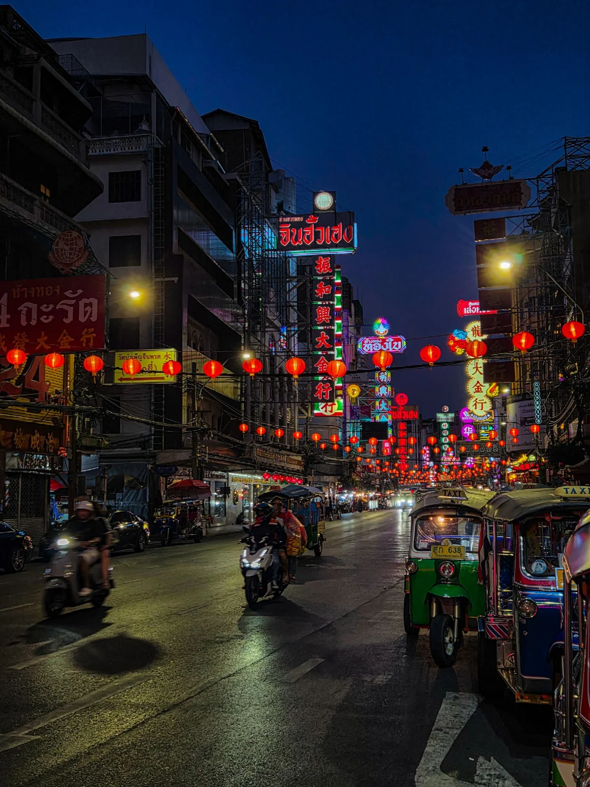 Illuminated signs and evening street life in Bangkok Chinatown