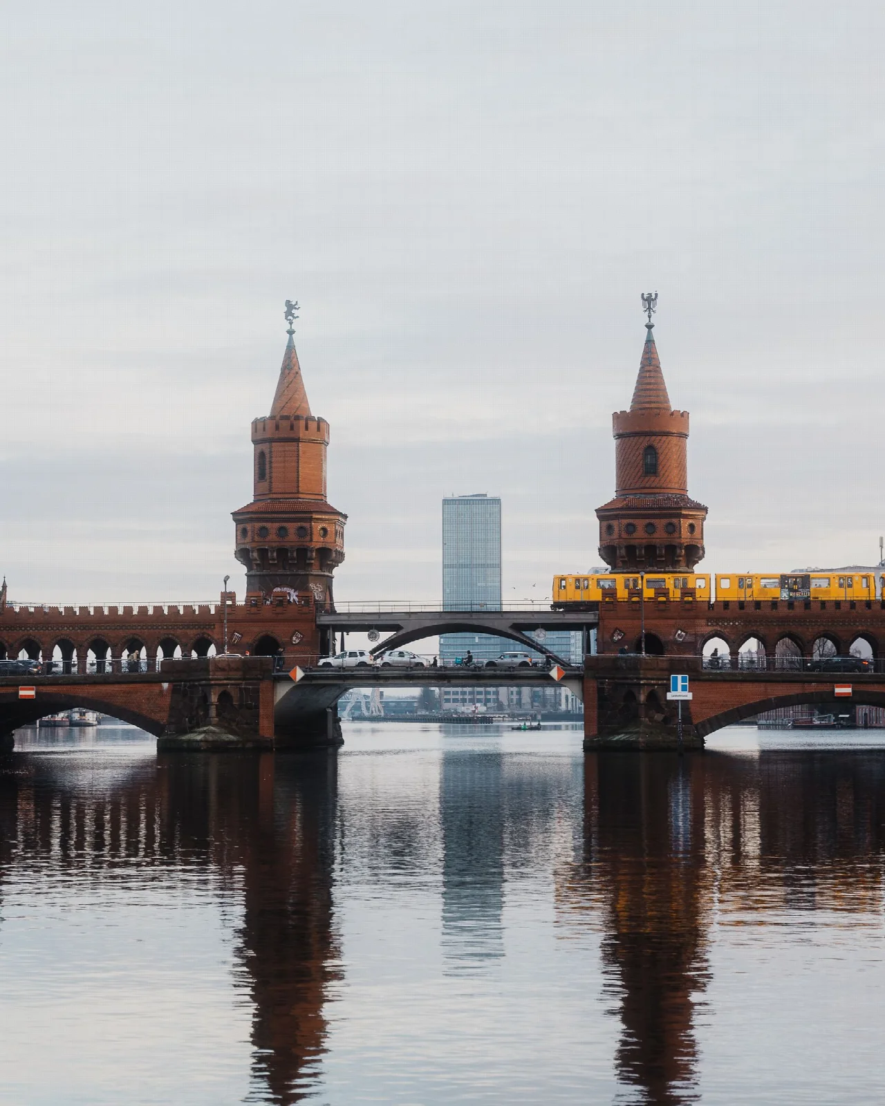 Spree üzerinde Oberbaum Köprüsü, sarı tren ve su yansımaları