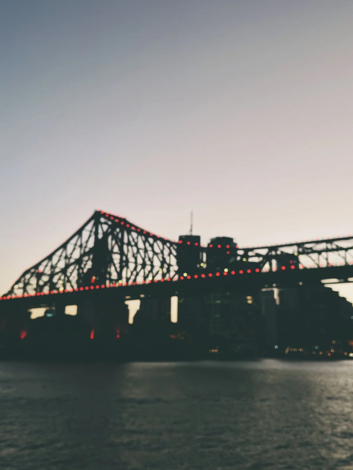 Brisbane Nehri kıyısından Story Bridge’in çelik yapısı ve akşam gökyüzü