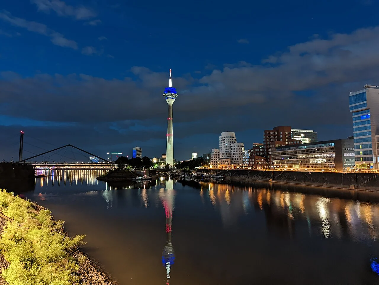 Night lights around Düsseldorf’s MedienHafen reflected on the Rhine, photographed in June 2022.