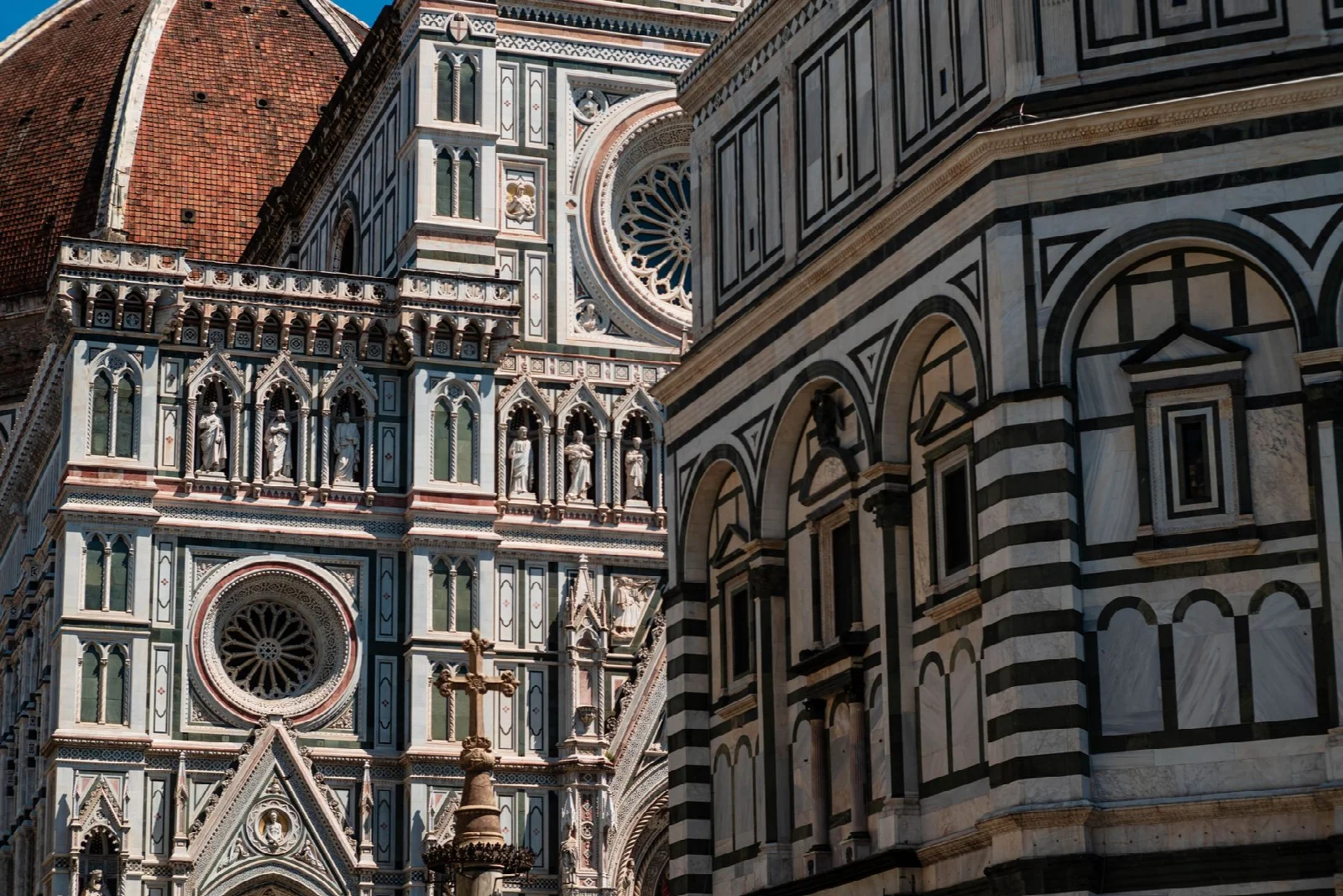 Marble patterns, arches and sculptures on the facade of Florence Cathedral