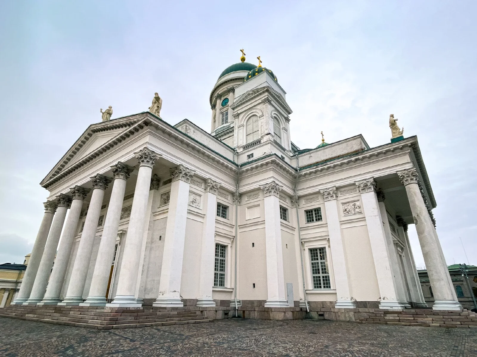 Bulutlu gökyüzü altında beyaz sütunları ve kubbeleriyle Helsinki Katedrali