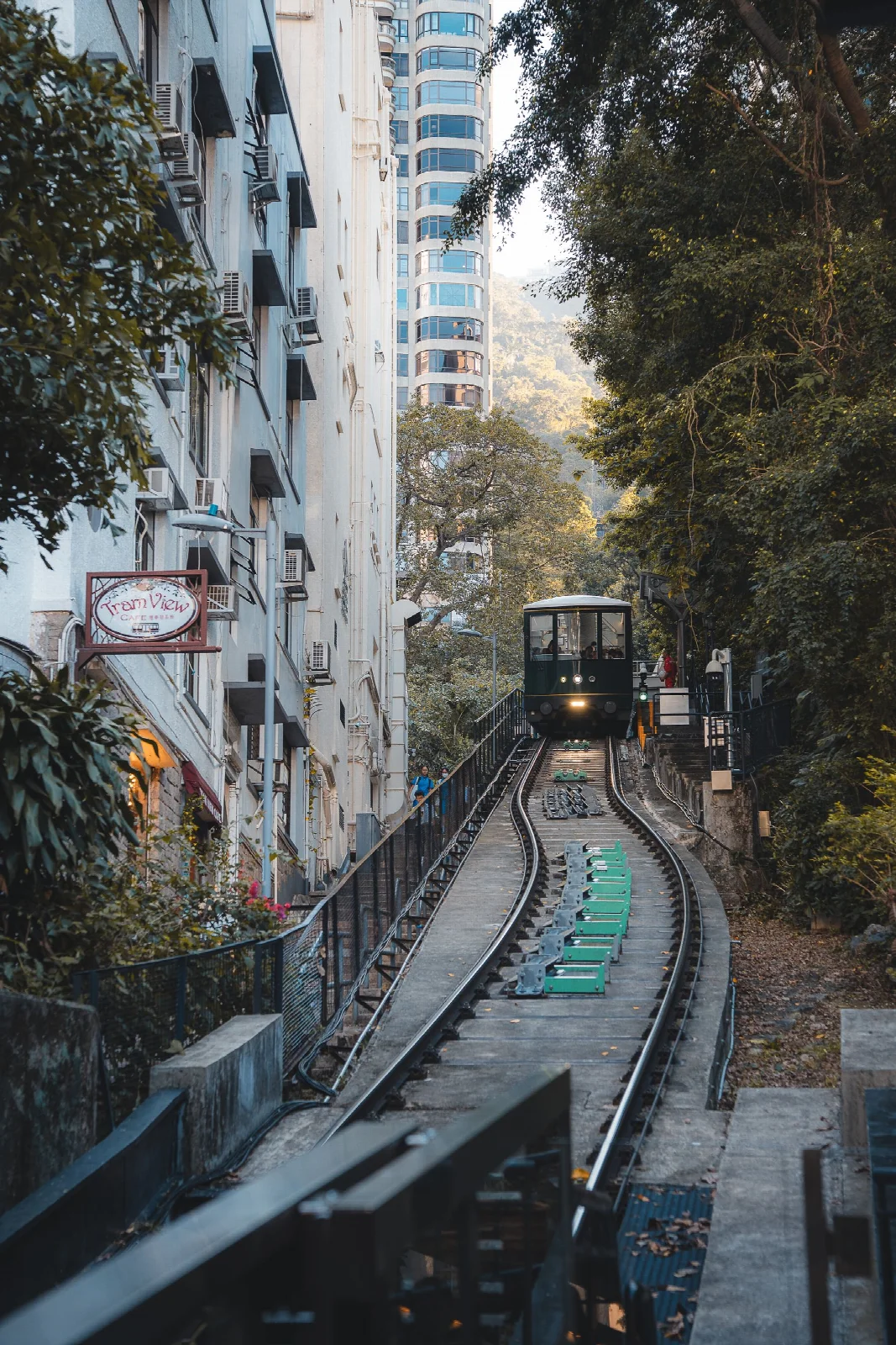 Hong Kong Peak Tram raylarının binalar ve ağaçlar arasındaki yükselişi