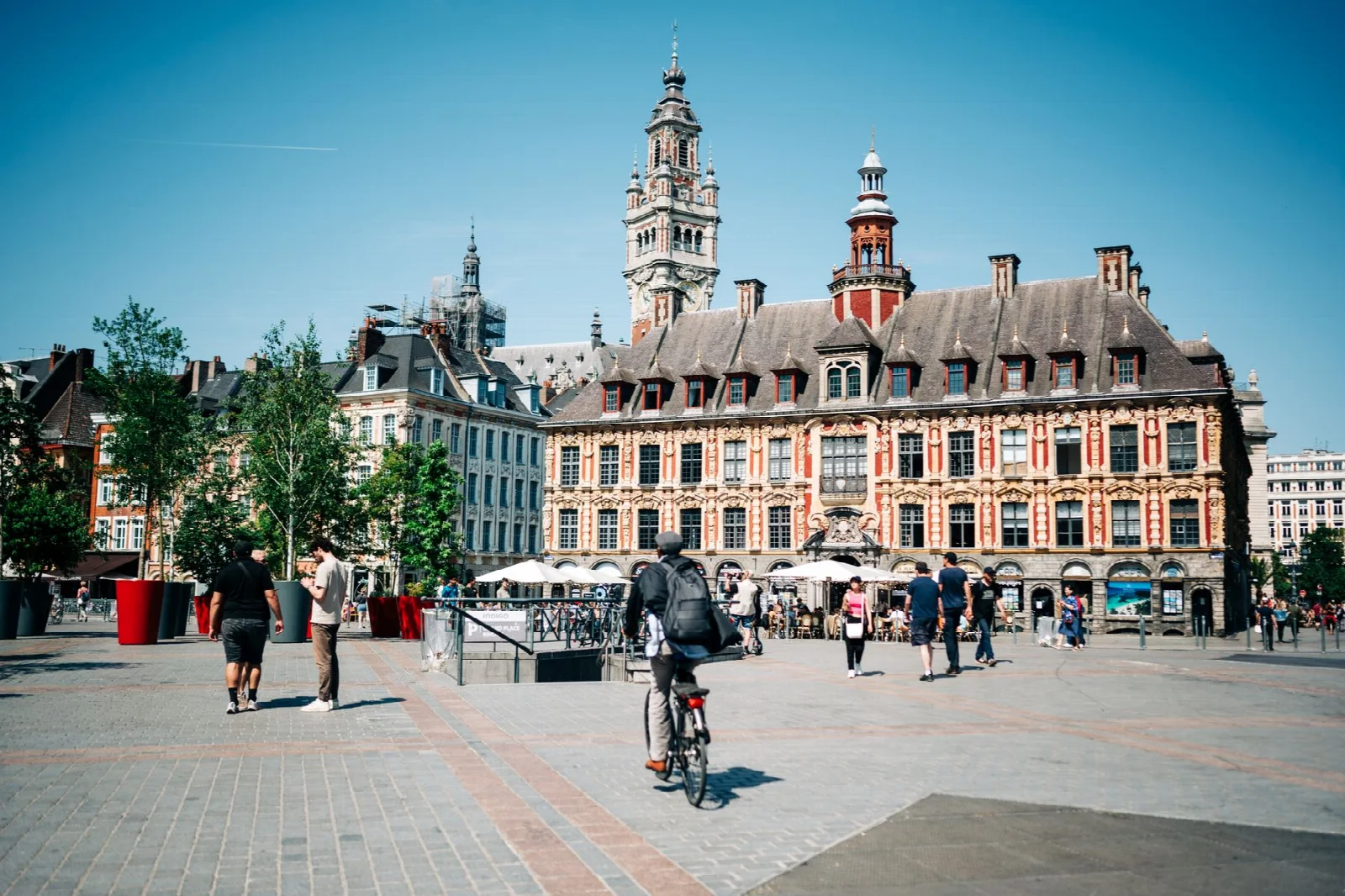 The Old Stock Exchange and people walking through Grand Place in Lille