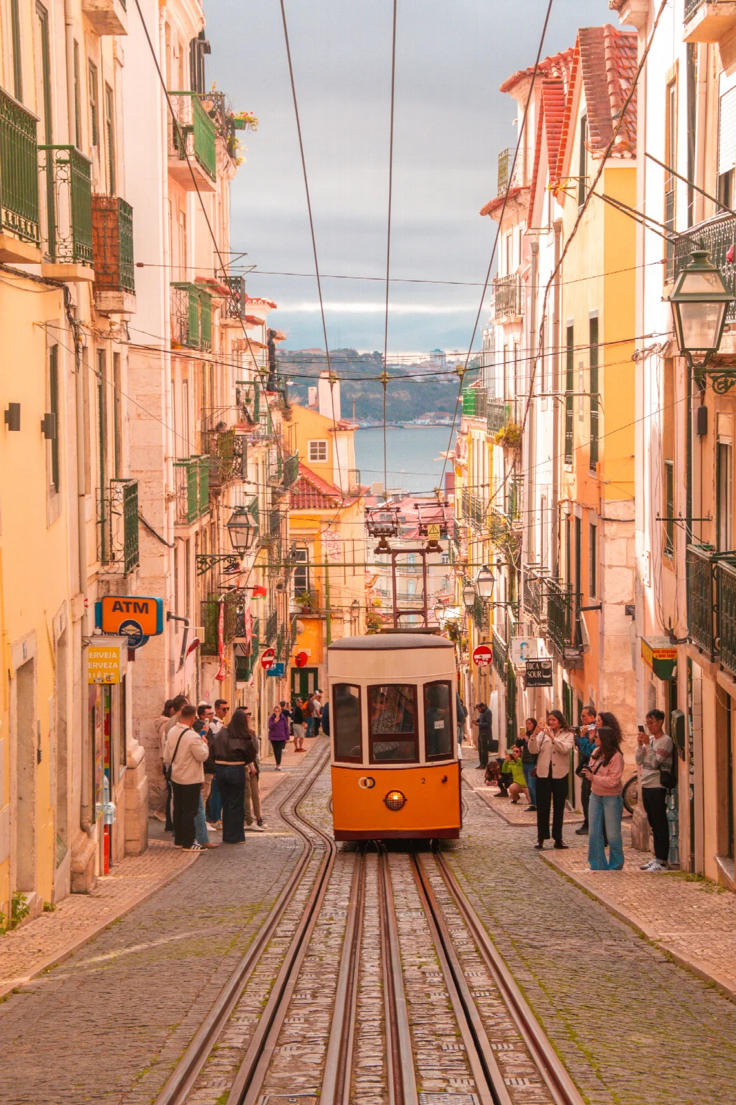 Tracks and a yellow funicular along the steep street in Bica, Lisbon
