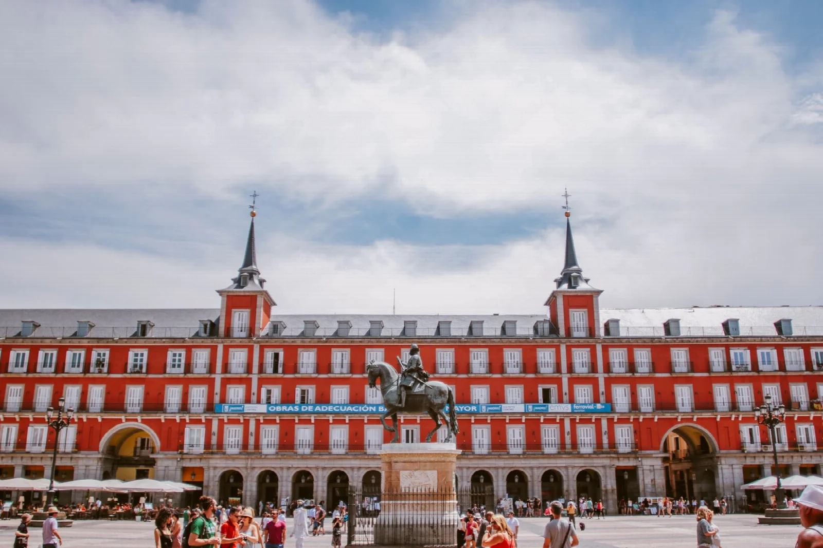 Madrid Plaza Mayor’da kemerli geçitler, kırmızı cepheler ve meydandaki insanlar