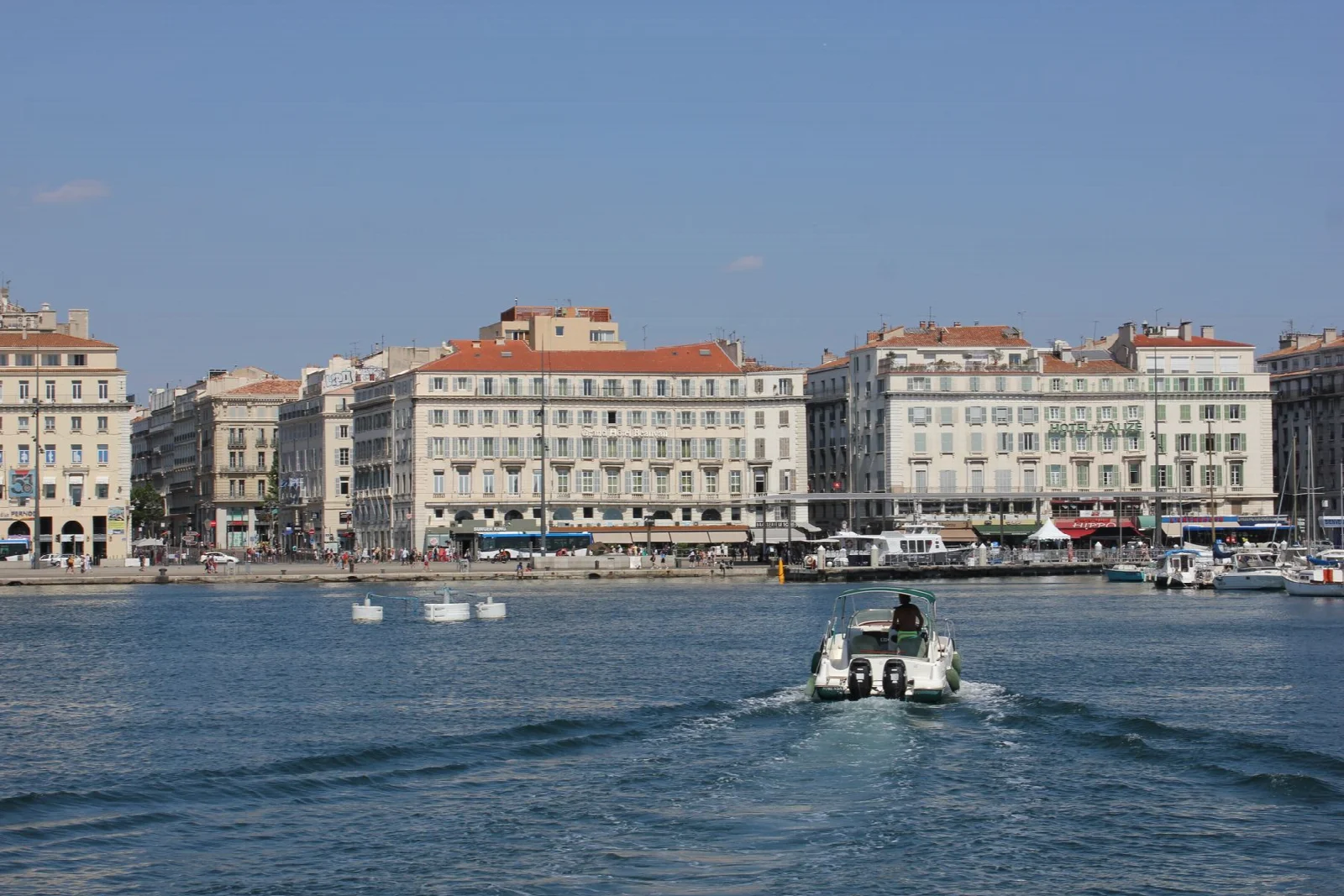 Boats, water and historic waterfront buildings at the entrance to Marseille harbour