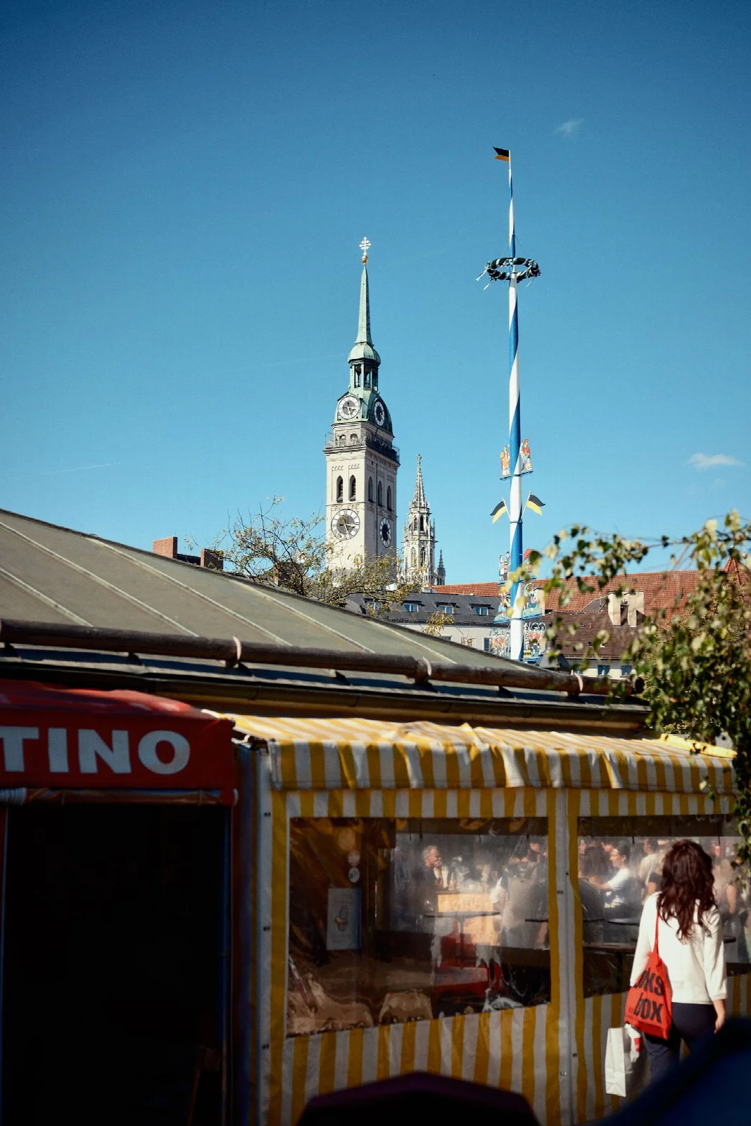 Münih Viktualienmarkt çevresindeki pazar tezgâhları ve kilise kulesi