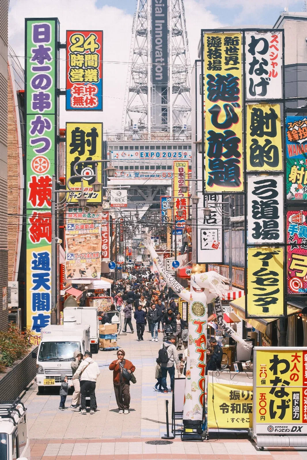 Osaka Shinsekai sokaklarında tabelalar ve ziyaretçiler; Jin Zhang. Kısa yemek yürüyüşünün şehir bağlamı.