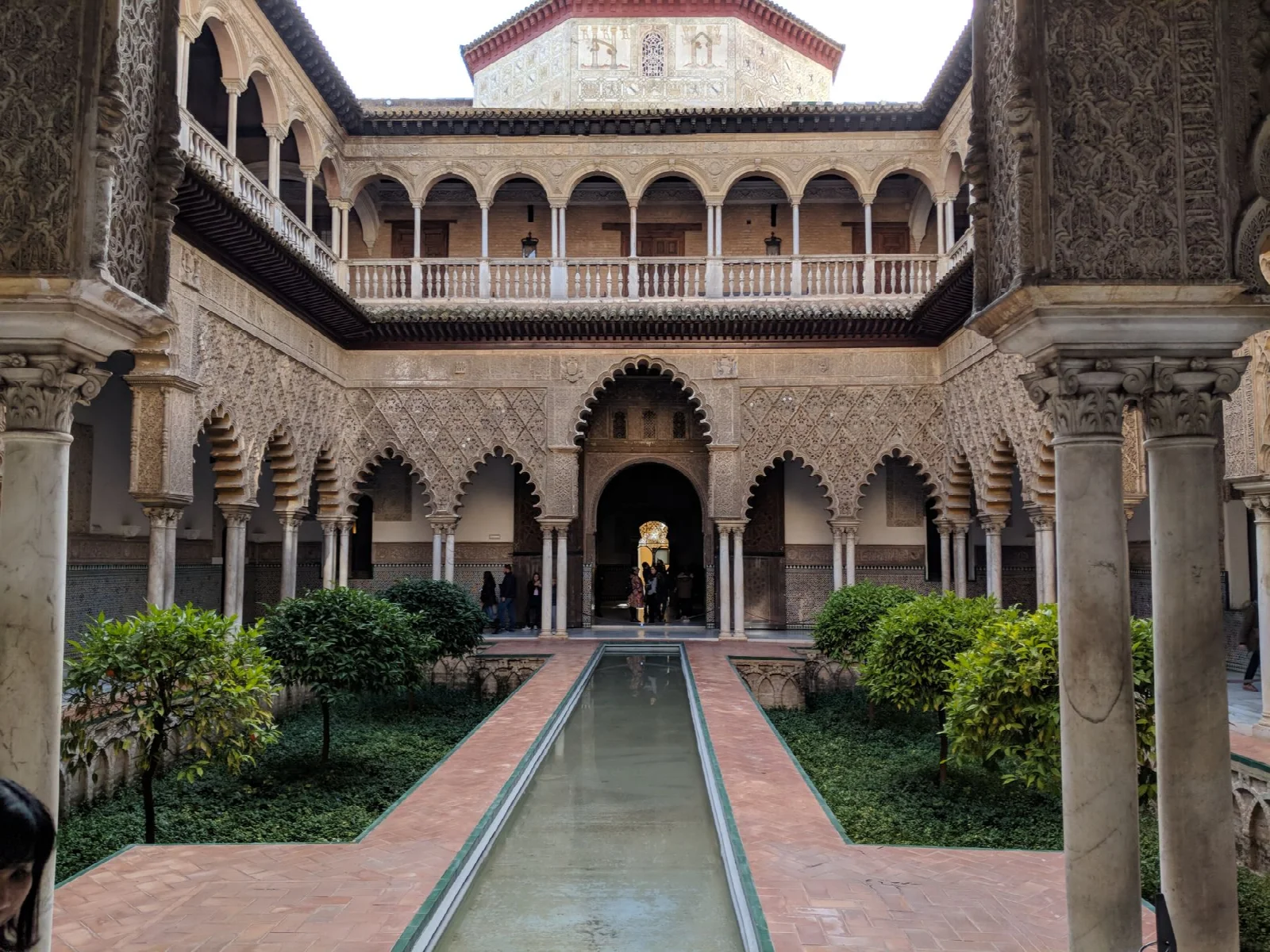 Sevilla Alcázar’ında kemerli avlu, ince bezemeler ve su yüzeyi